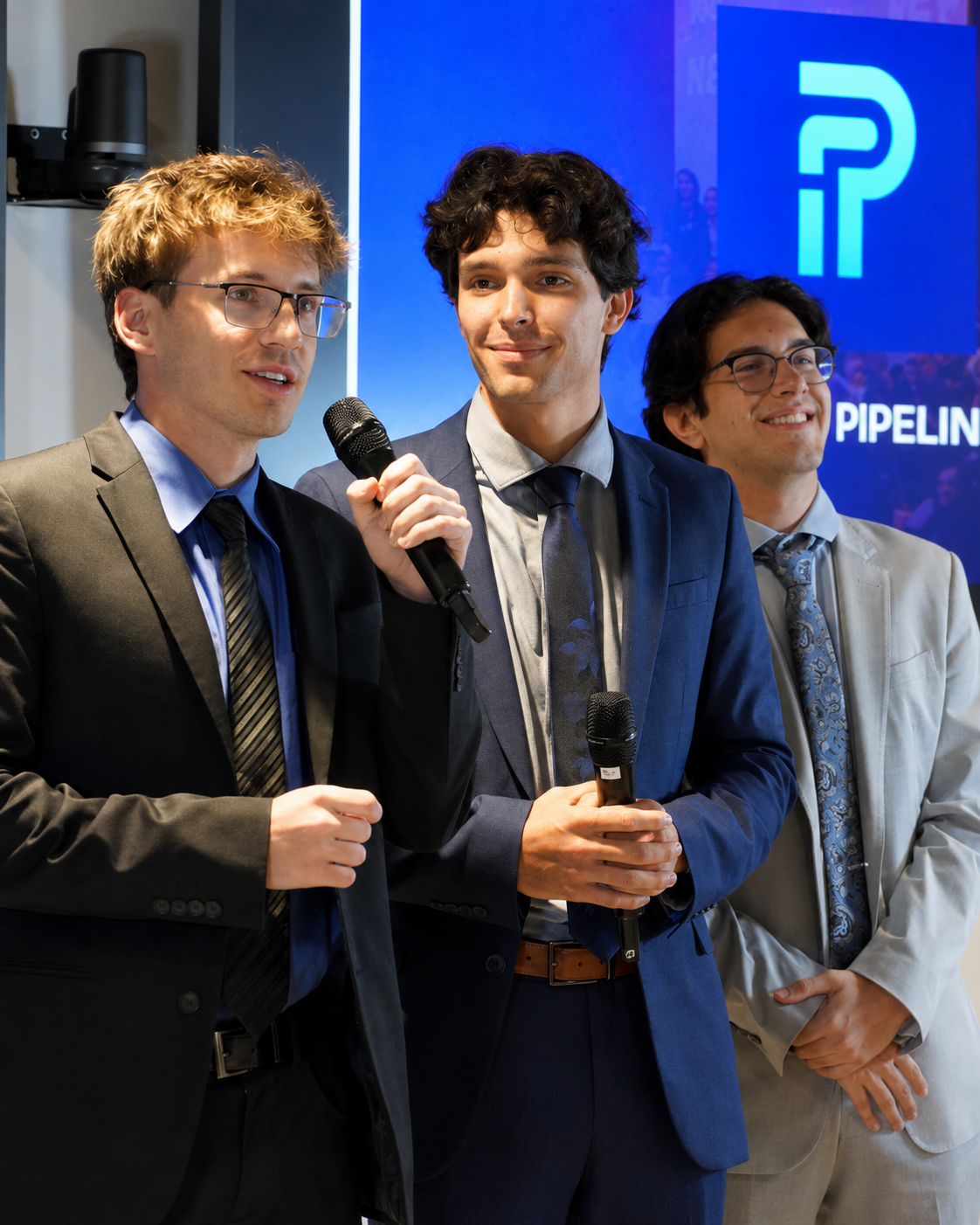 Three Sunstone Brand Lab founders speaking on stage with microphones at a Pipeline demo event